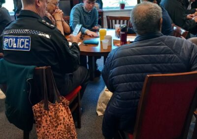 Speaker Inspector Paul Ciro sitting round table talking